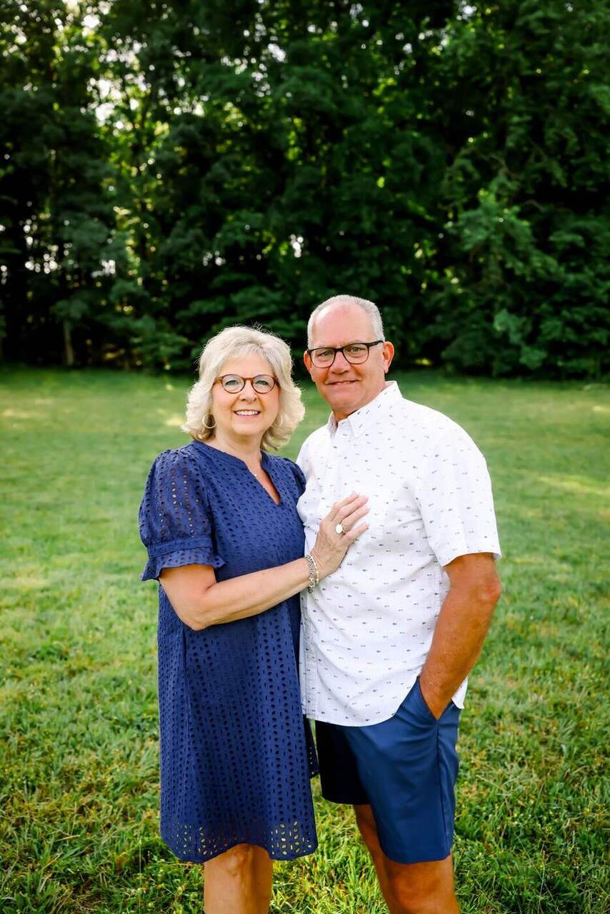 Robin and Phil standing together in a green field