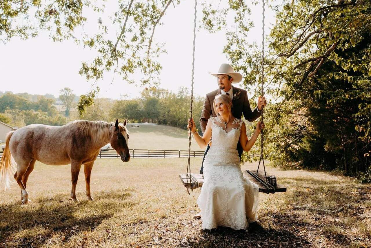 Bride on the rope swing with a horse beside her